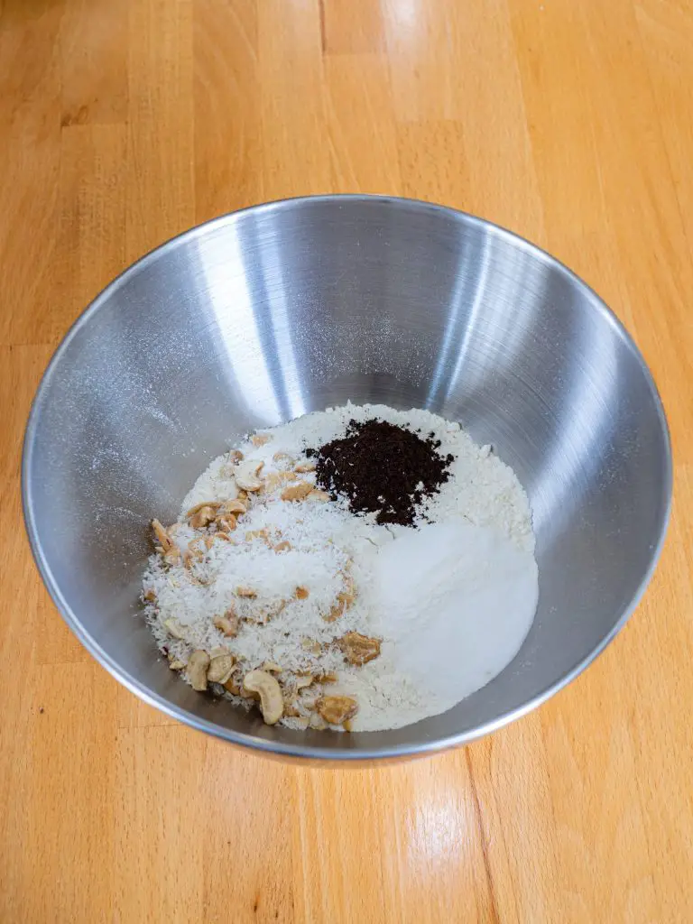 3. Mélanger la farine, le bicarbonate, la levure chimique, la noix de coco râpée, les noix de cajou et le sel. Incorporer aux ingrédients liquides.