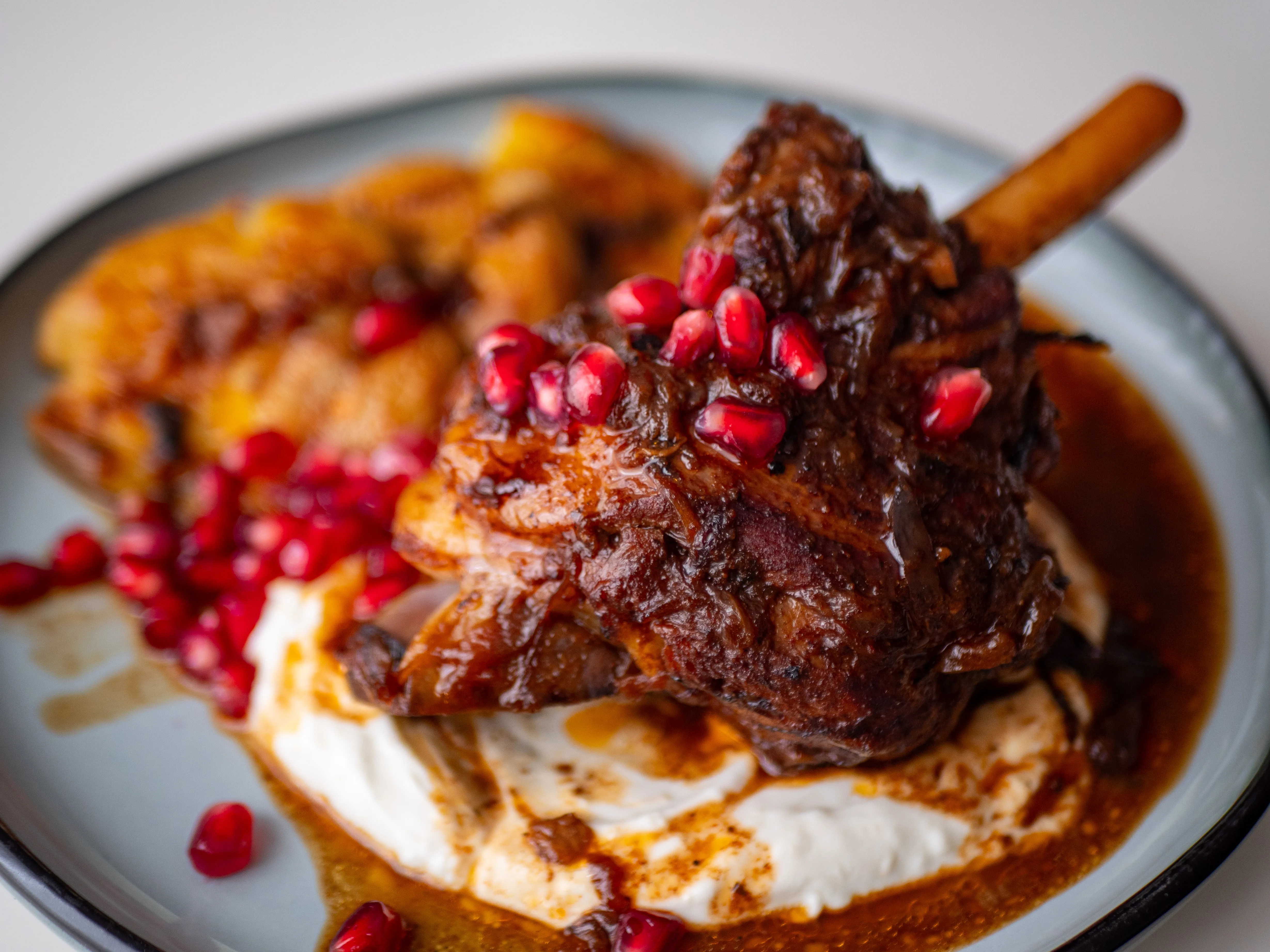 Souris d’agneau confite aux épices douces, yaourt citronné & grenade